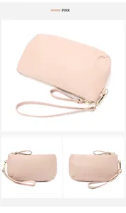 Detail view of pink pebbled leather wristlet wallet with gold zipper and strap