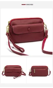 Detail view of wine red lychee grain leather crossbody bag with gold hardware