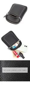 Macro view of black litchi cowhide phone bag with white stitching and dual silver zippers