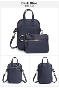 Detail of dark blue lychee grain leather crossbody bag set with silver hardware