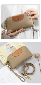 Detalle del bolso bandolera de cuero en contraste con textura lichi y hebilla dorada
