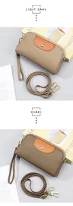 Detalle de bolsos bandolera de cuero gris claro y caqui con herrajes dorados