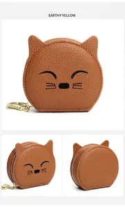 Detailansicht der gelben Leder-Münztasche mit Katzenmotiv und Metall-Schlüsselanhänger