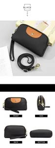 Detalle de bolso bandolera de cuero negro con patchwork marrón y herrajes de metal dorado