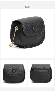 Drie weergaven van een zwarte mini-crossbodytas van generfd leer met gouden ketting