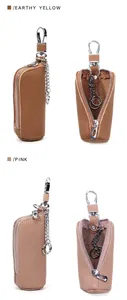 Detail of leather car key pouch with zipper and hook in pink and earthy yellow