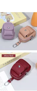 Dettaglio di mini borse in pelle a grana con moschettoni metallici e chiusure magnetiche