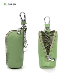 Macro shot of green pebble leather car key case with silver zipper and snap hook clip