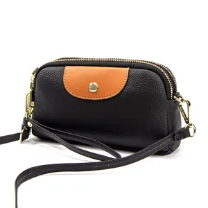 Bolso bandolera de cuero negro con solapa de contraste marrón y cremalleras doradas