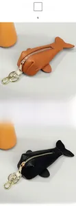 Detail of fish-shaped leather key pouches with lychee grain and gold metal zippers