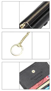 Detail of black pebble grain leather wallet showing gold zipper and genuine leather stamp