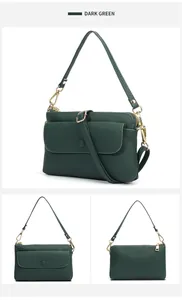 Detail view of dark green pebbled leather crossbody bag with multiple zip compartments