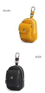 Vista dettagliata di mini borse portamonete in pelle gialla e nera con moschettoni argento