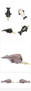 Detailed views of a leather whale-shaped key pouch with gold hardware and internal storage