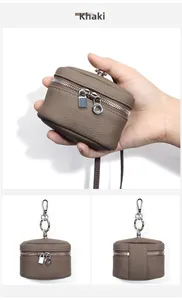 Close-up of khaki leather mini pouch with metal swivel hook and textured litchi grain