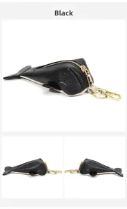 Detail of fish-shaped black leather key case with gold hardware and litchi texture