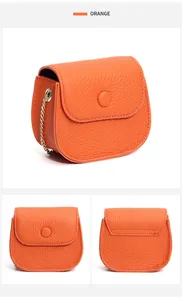 Makroaufnahme der orangefarbenen Mini-Umhängetasche aus Leder mit goldener Kette