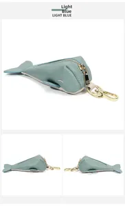 Detailed view of light blue leather whale keychain with gold zipper and pebble texture