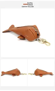 Detailed view of earthy yellow leather whale keychain with golden zip and hardware