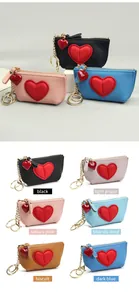 Detail of multi-color heart-shaped leather coin purses with golden keychains and zippers
