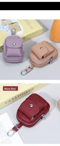 Dettaglio di mini borsellini in pelle martellata bordeaux e beige con ganci in metallo