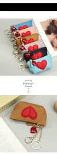 Close-up of leather heart purses in various colors with metallic zippers and keychains