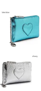 Détail de porte-monnaie en cuir bleu lac et argent avec couture cœur et chaînes