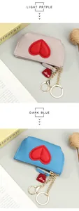 Detailed macro view of litchi grain leather coin purses with heart patches and gold keychains