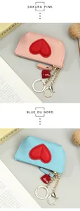 Detail of lychee pattern leather mini wallets with red heart pendant and gold zipper