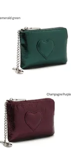 Détail de pochettes cœur en cuir vert émeraude et violet champagne avec chaînes