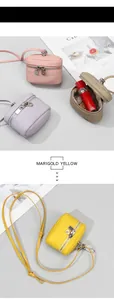 Detail of mini leather pouches in pastel tones with litchi grain and silver zippers