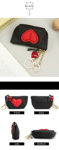 Detail of black pebbled leather mini wallet with red heart charm and gold hardware