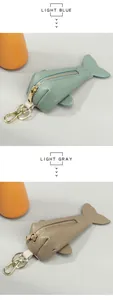 Close-up of fish-shaped leather key pouches with gold zippers in light blue and grey