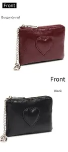 Détail du porte-monnaie en cuir avec patch cœur, fermeture éclair et chaînette