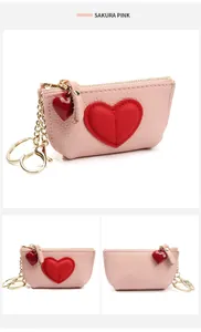 Macro view of sakura pink pebble leather coin purse with red heart patch and gold keychain