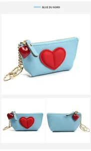 Detail of light blue leather coin purse with red heart charm and gold hardware