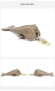 Detail view of fish shaped light gray leather key pouch with golden zipper and hook