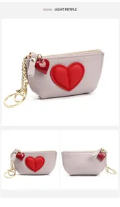 Macro detail of purple leather coin purse with red heart patch and gold keychain