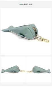 Detail view of light blue whale-shaped genuine leather key pouch with gold hardware