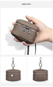 Detail of khaki pebbled leather mini pouch with dual silver zippers and metal hook