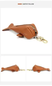 Detail view of earthy yellow whale-shaped leather key pouch with gold metal hardware