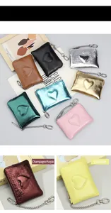 Détail de mini portefeuilles en cuir véritable avec couture cœur et chaîne en métal