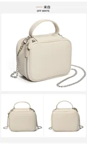 Vue détaillée du sac à main en cuir grainé blanc cassé avec fermetures éclair argentées