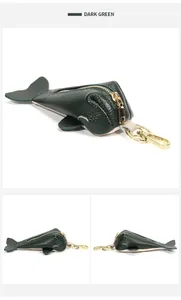 Macro view of dark green fish-shaped leather key pouch with golden zipper and clip
