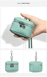 Detail view of light green lychee leather mini crossbody pouch for coins and earphones