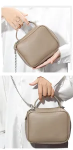Vue détaillée du cuir grainé taupe et de la bandoulière en chaîne argentée du sac à main
