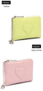 Vue de face des porte-monnaie en cuir jaune et rose sakura avec patch cœur et fermeture