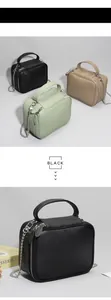 Détail du sac à main en cuir grainé avec chaîne en métal et fermeture à double zip