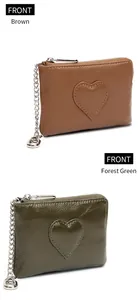 Détail de porte-monnaie en cuir marron et vert forêt avec coutures cœur et chaînes