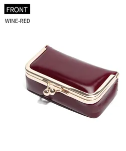 Front view of a wine-red vintage oil wax leather mini jewelry bag with gold kiss lock closure